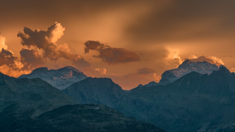 Berge und Wolken die das goldene Dämmerlicht der untergehenden Sonne, beim Sundowner in der Silvretta Montafon, reflektieren  | © Silvretta Montafon - Vanessa Strauch