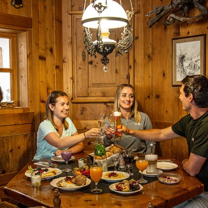 Drei Personen in einer gemütlichen Holzstube beim Bergfrühstück in der Nova Stoba in der Silvretta Montafon. | © Silvretta Montafon - Vanessa Strauch