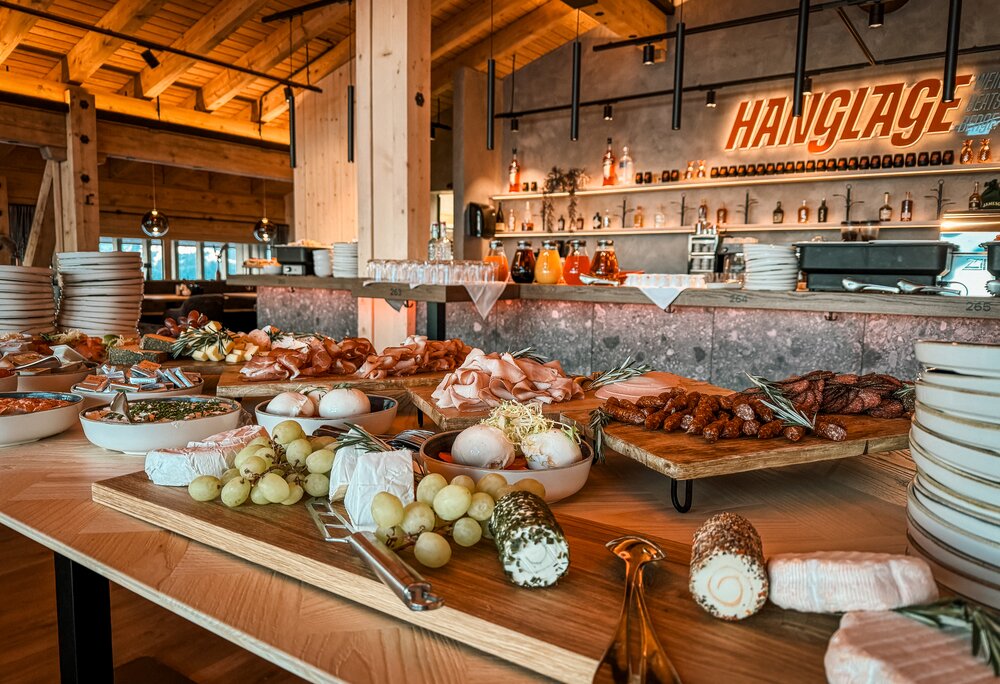 Ein gedecktes Frühstücksbuffet mit Käse, Wurst und Säften. | © Silvretta Montafon - Vanessa Strauch