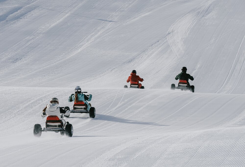 Vier Personen fahren auf einem Mountaincart auf einer Skipiste. | © Silvretta Montafon - Niklas Kirchler