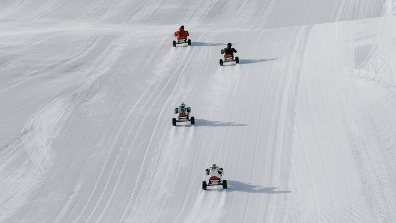 Vier Personen fahren auf einem Mountaincart auf einer Skipiste. | © Silvretta Montafon - Niklas Kirchler