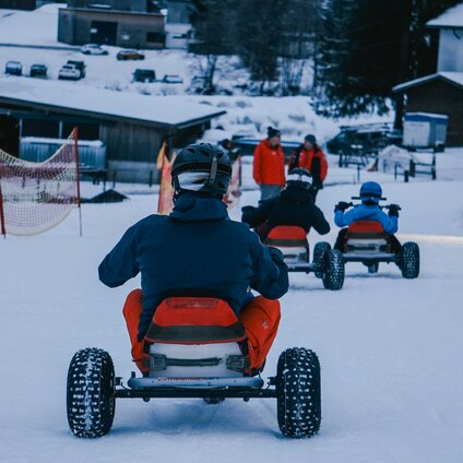 Eine Gruppe von Personen in Skikleidung bei der Zieleinfahrt der Mountaincarts-Strecke. | © Silvretta Montafon - Vanessa Strauch
