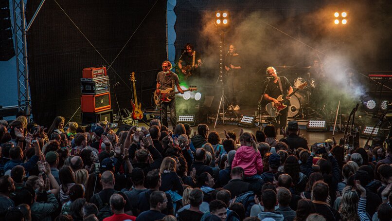 Ein Konzert beim Sonnenuntergang mit bunter Beleuchtung und großem Publikum | © Silvretta Montafon - Frederike Weber