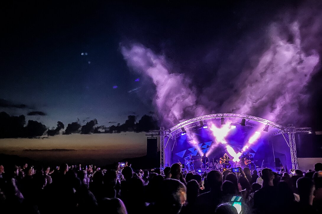 Ein Konzert beim Sonnenuntergang mit bunter Beleuchtung und großem Publikum | © Silvretta Montafon - Frederike Weber