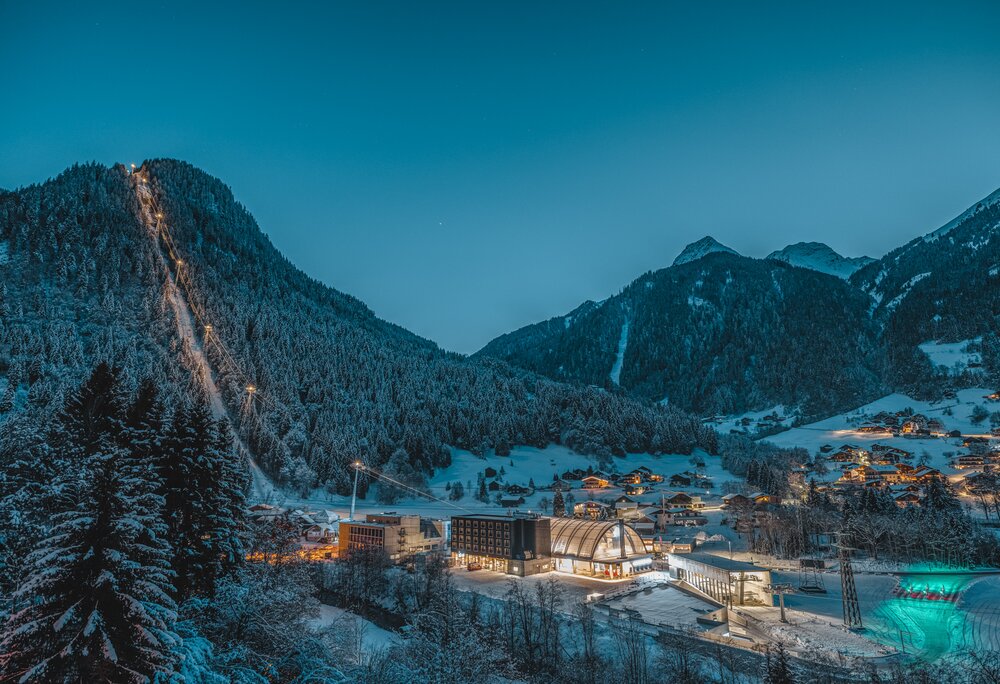 Die Valisera Bahn erleuchtet bei Nacht mit schneebdeckten Bäumen und Bergspitzen | © Silvretta Montafon - Mathäus Gartner