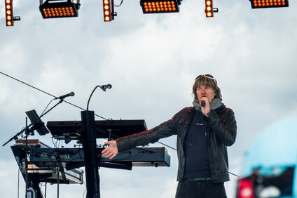 Mickie Krause in schwarzer Bekleidung singt auf der Bühne in den Bergen | © Silvretta Montafon - VONIHR Productions