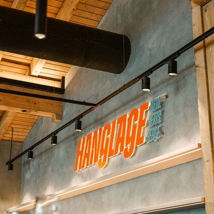 Der orange beleuchtetet Schriftzug des Restaurants Hanglage am Hochjoch. | © Silvretta Montafon - Vanessa Strauch