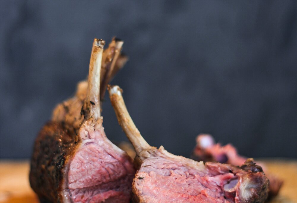 Eine Keule vom Montafoner Steinschaf mit Pfefferkerner auf einem Holzbrett | © Silvretta Montafon - Anna Wittwer