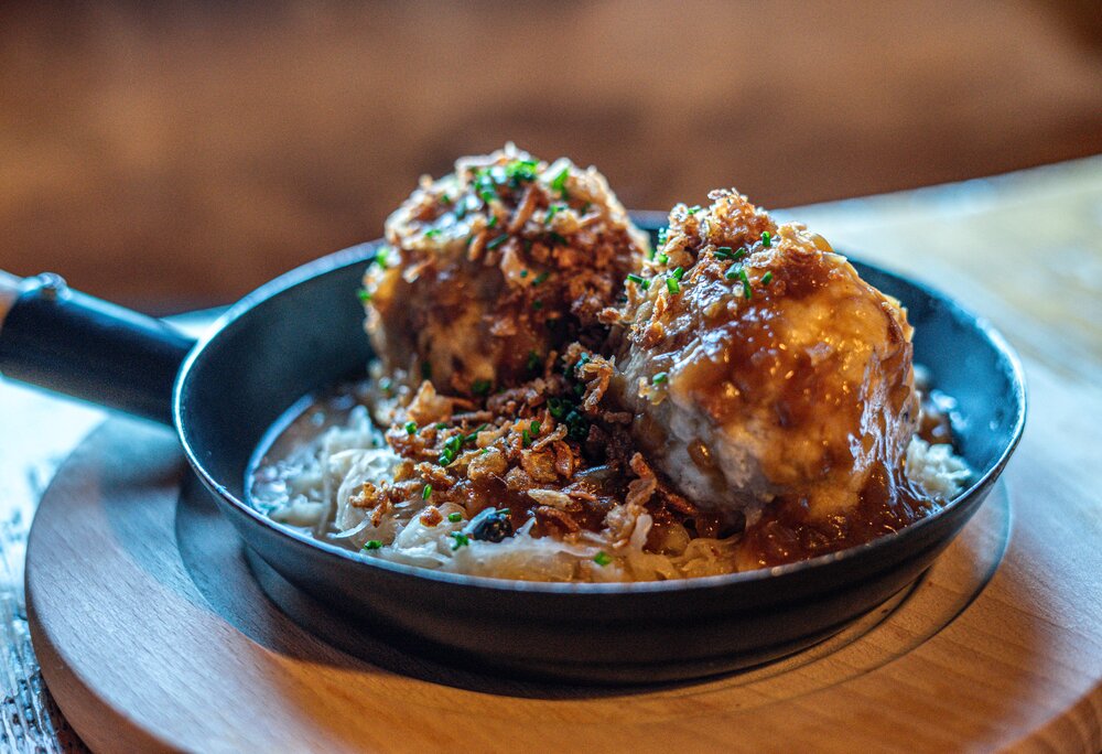 Eine Pfanne mit zwei Semmelknödeln und Sauerkraut im Valisera Hüsli in der Silvretta Montafon. | © Silvretta Montafon - Vanessa Strauch