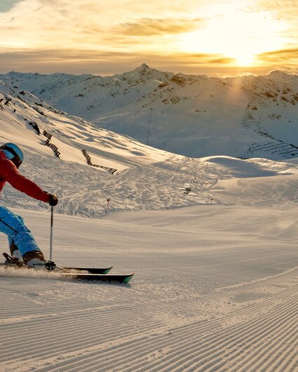 Ein Skifahrer fährt über die frisch präparierte Piste bei Sonnenaufgang bei der HochjochTotale in der Silvretta Montafon | ©  Silvretta Montafon - Stefan Kothner